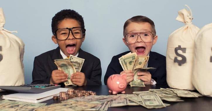 Deux enfants jouent et rient en manipulant des billets de banque